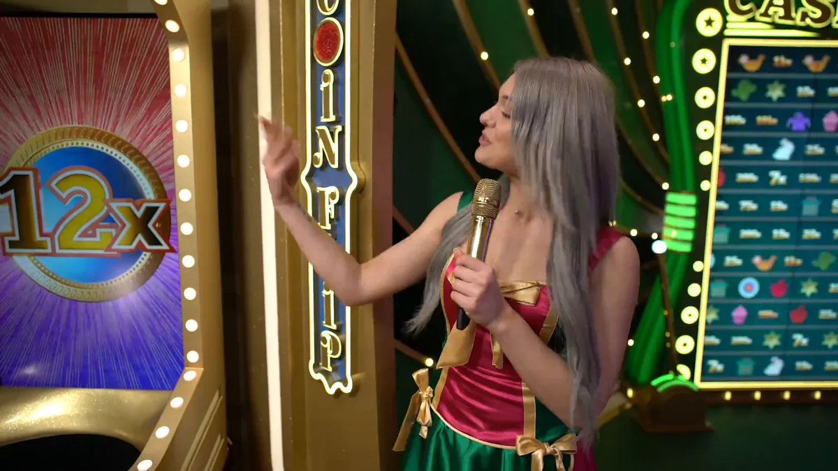 La conduttrice di Crazy Time accanto alla colonna Coin Flip con un 12x